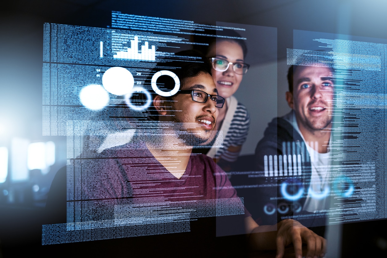 IT specialists using software and data reflected in a computer monitor to review company services.